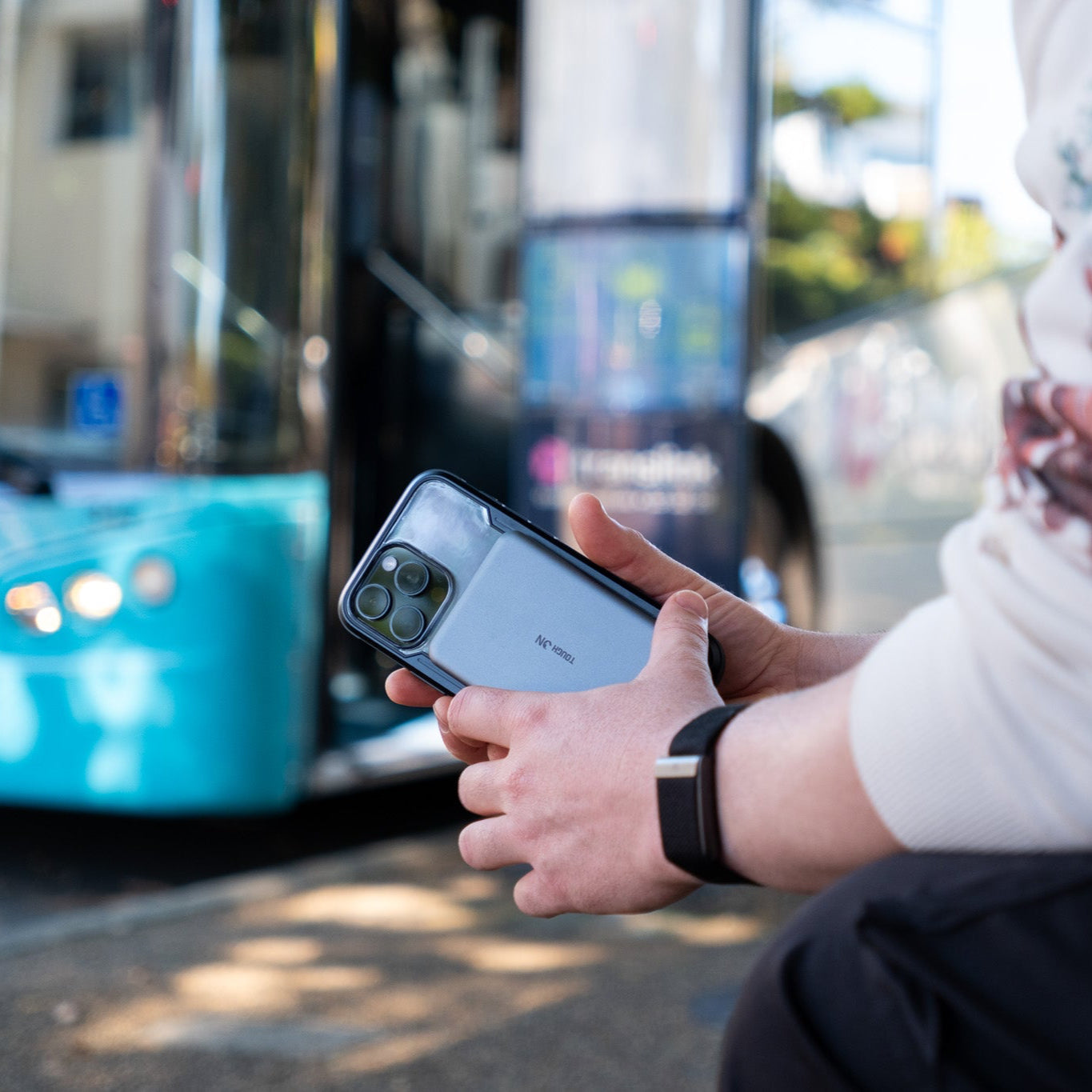Ultra slim power bank in a persons hand waiting for bus